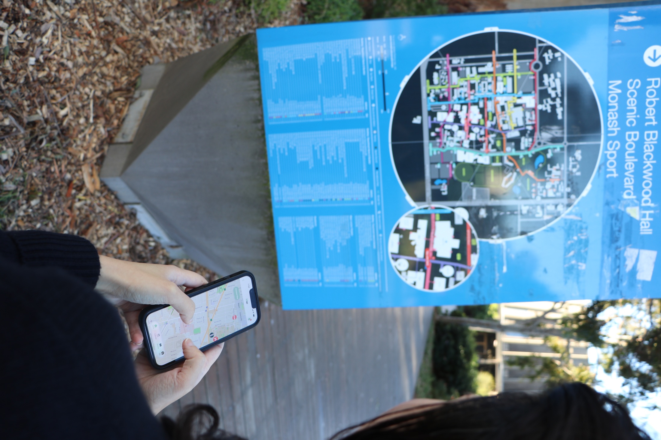 A participant testing the mobility interface beside a campus wayfinding map